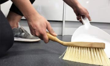 maid using broom and dust pan to easily sweep up debris from epoxy floor