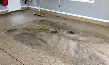 filthy epoxy floor that is being easily cleaned with a broom