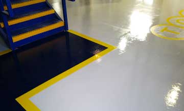 epoxy flooring in an industrial facility with safety lines added to the floor