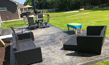 stamped concrete patio in the backyard; dusty black color