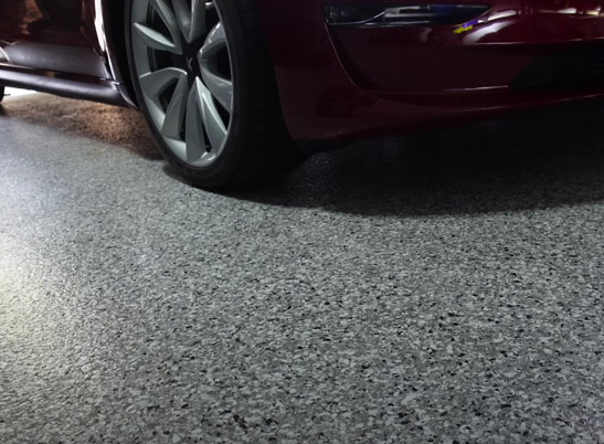 red car on gray and black flake epoxy garage floor