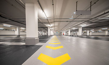 epoxy flooring in commercial parking garage - yellow epoxy painted arrows